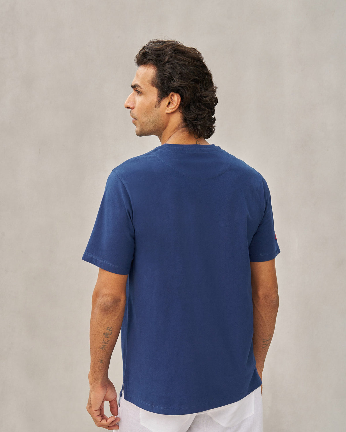 Back of a navy Party Cheetah T-shirt worn by a person.