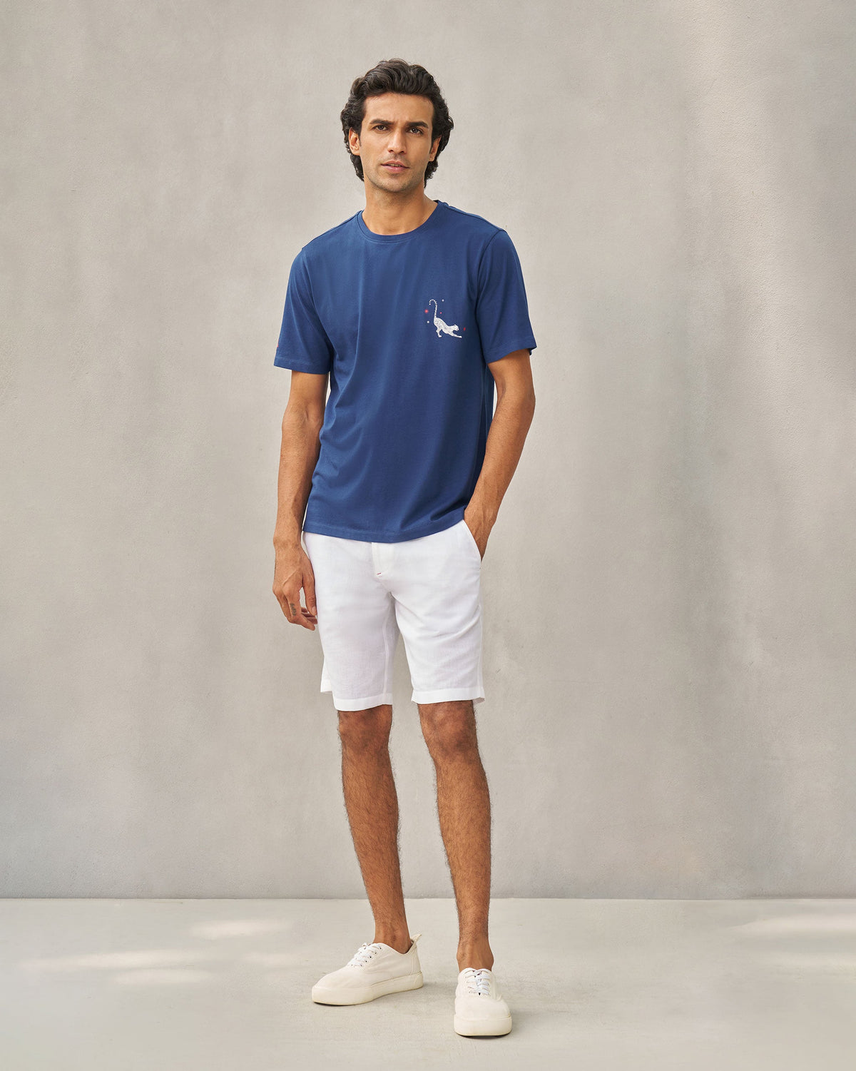 Full-length view of a navy Party Cheetah T-shirt with a small cheetah motif worn by a person.