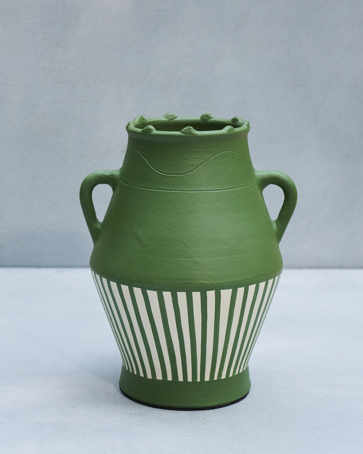 Moss Vase in green with a cream striped base and two side handles.