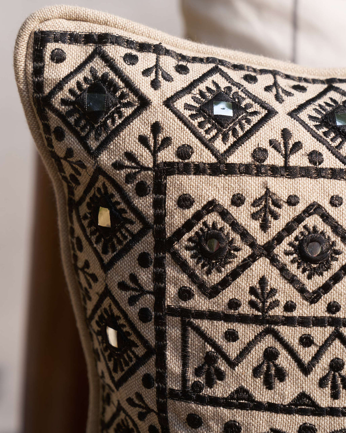 Corner of Morocco Mosaic Cushion Cover showing its black embroidery and piped edge.