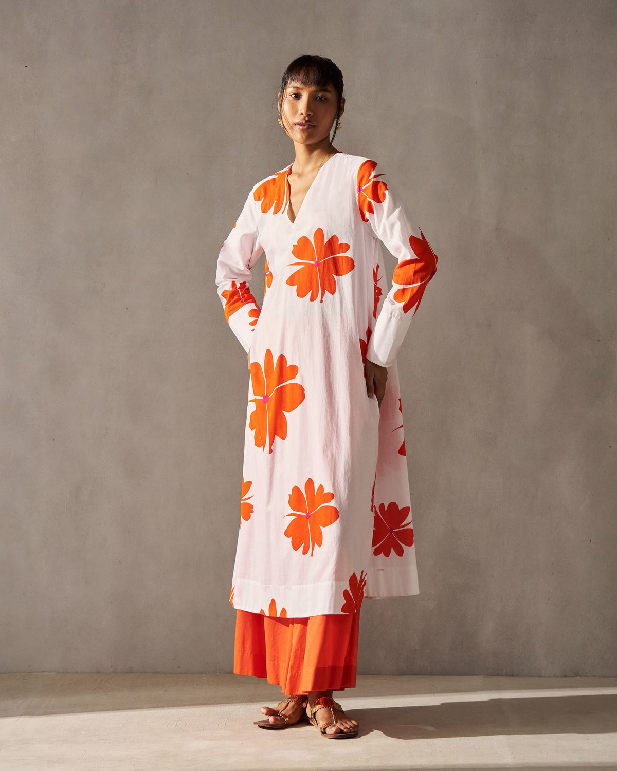 Person wearing a long-sleeved Flared V-neck Kurta with orange flower prints.