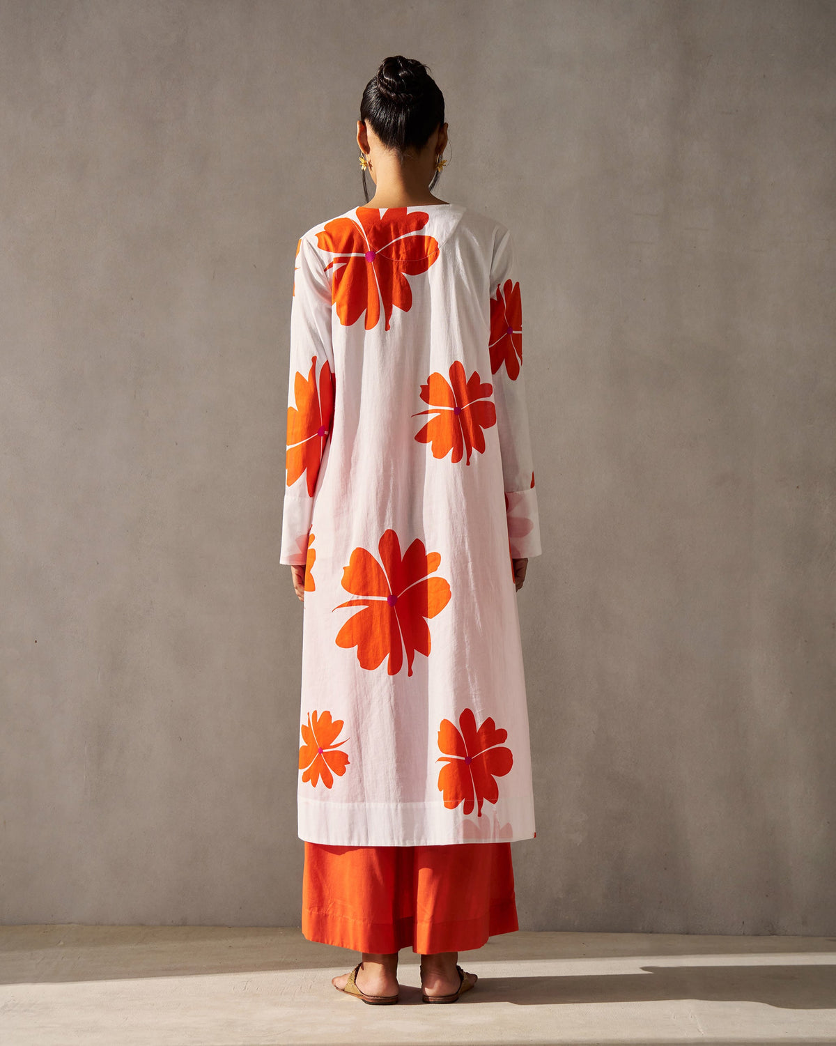 Back of the white Flared V-neck Kurta worn by a person, with orange flower prints.