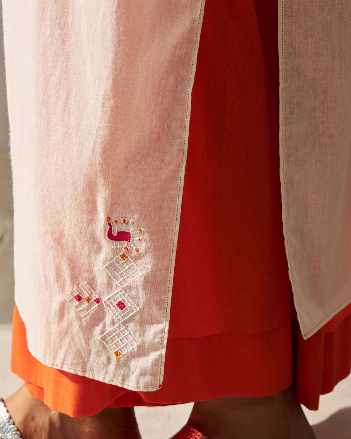 Close-up of an ivory Sara Gathered Kurta side panel with a small embroidered motif near the hem.