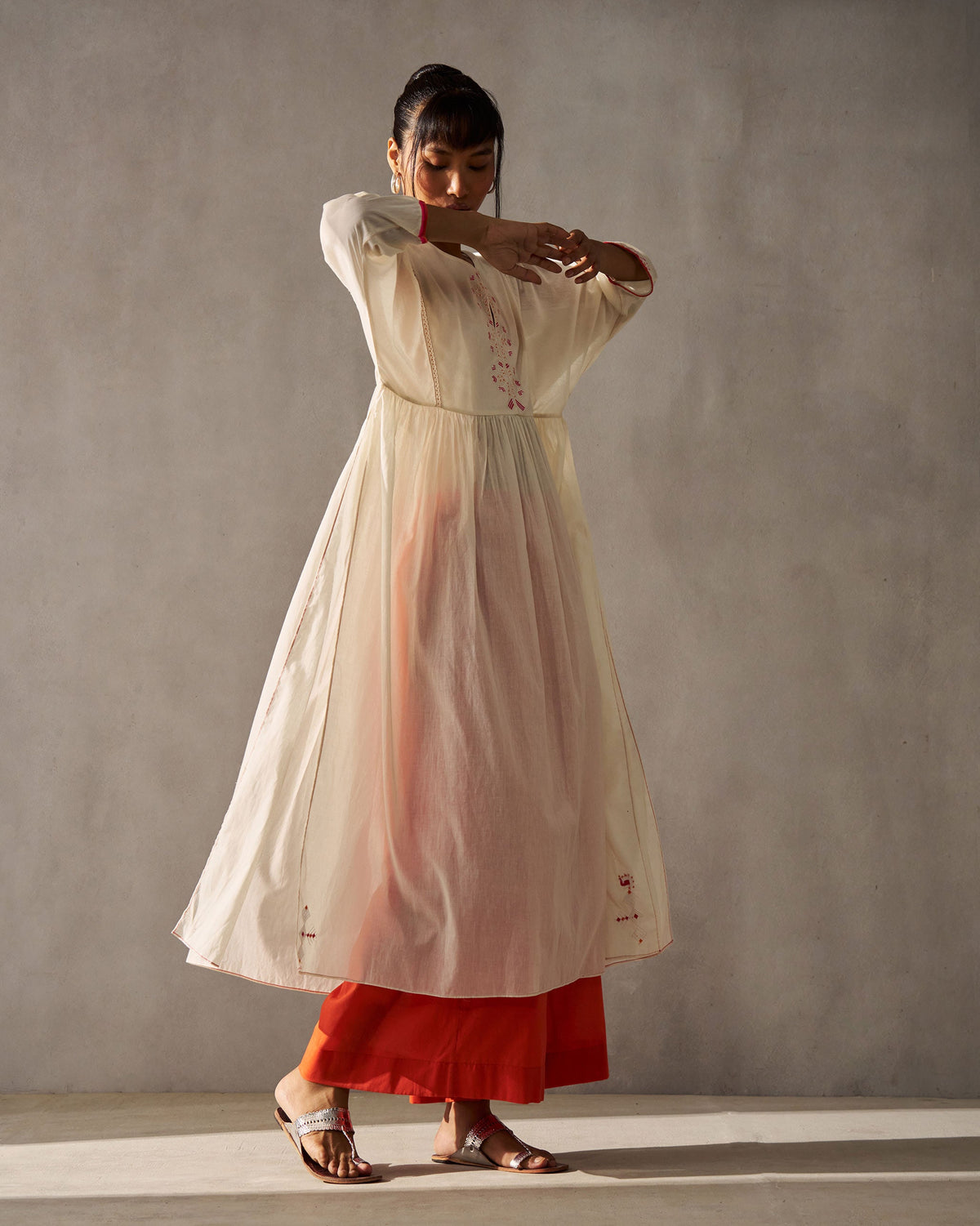 Person wearing an ivory Sara Gathered Kurta with a gathered waist, arms raised.