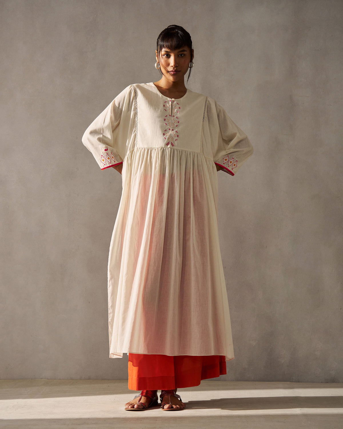 Person wearing an ivory Sara Gathered Kurta with placket embroidery, shown in full length.