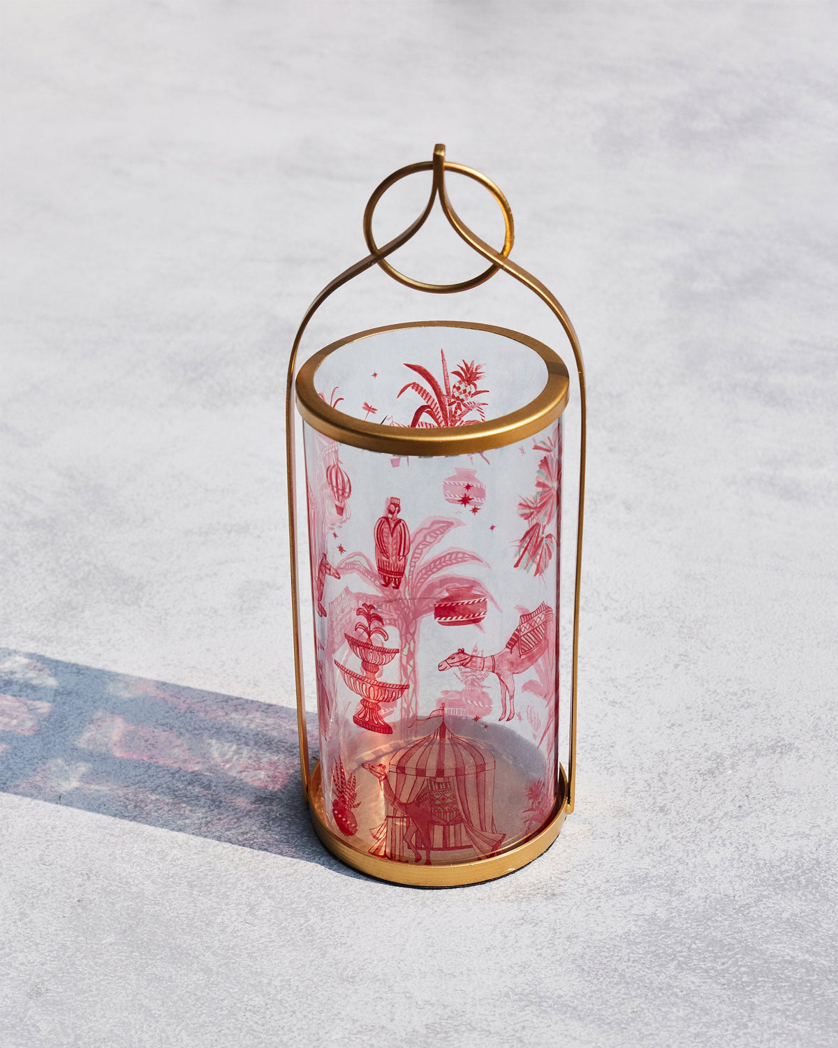 Atlas Lantern viewed from above, showing its red toile print on a grey surface.