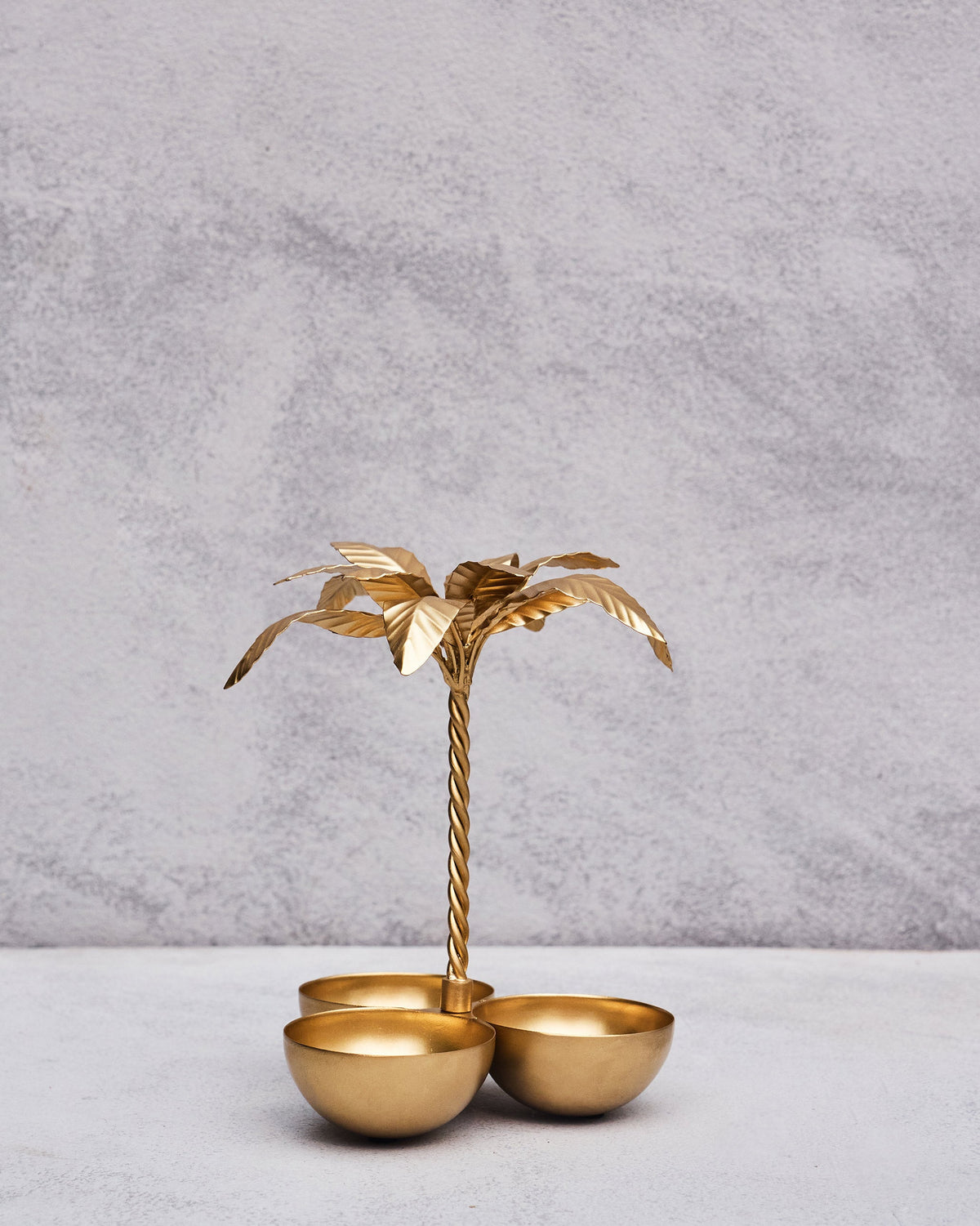 Palm Trinket Tray with gold leaves and three bowls at its base.