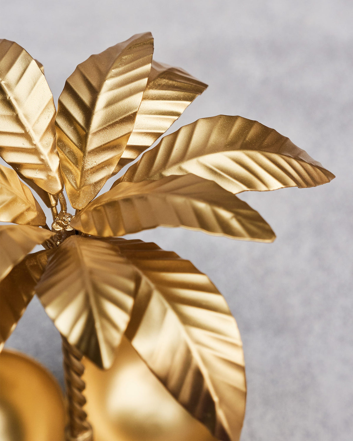 Close-up of Palm Trinket Tray showing its gold palm leaves with ridged detail.