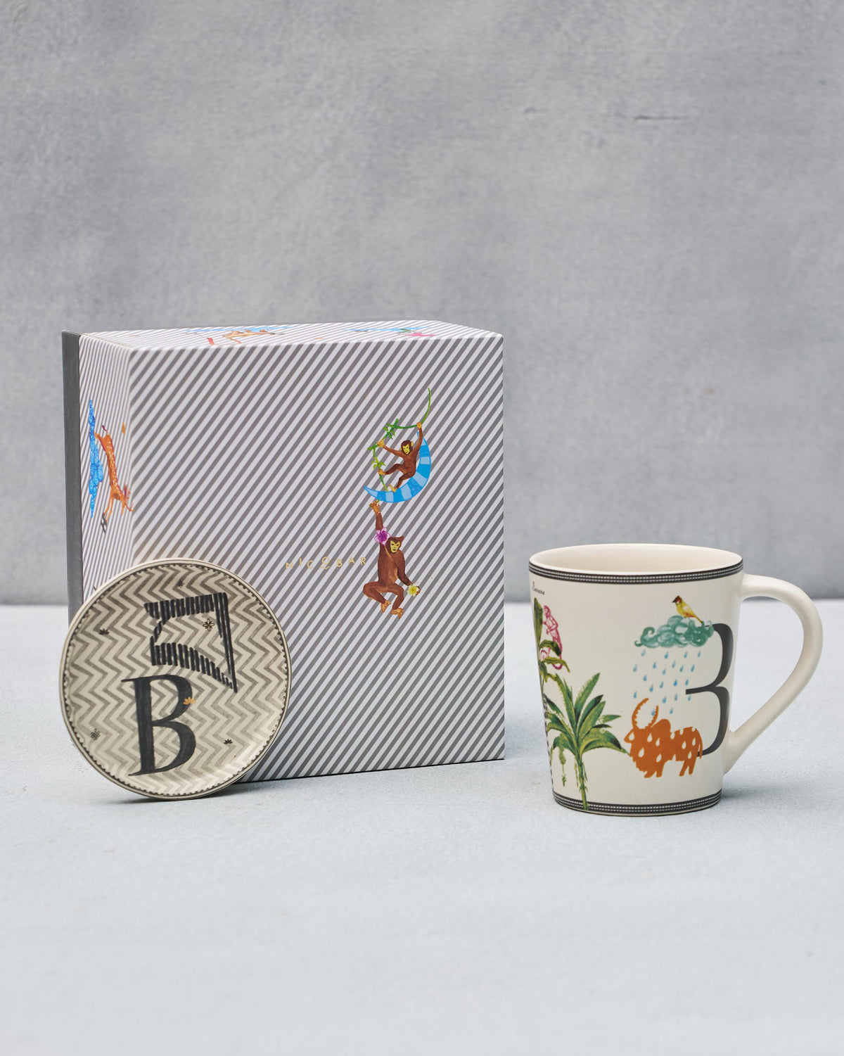 B Alphabet mug and coaster with letter B motifs beside a striped Nicobar gift box.