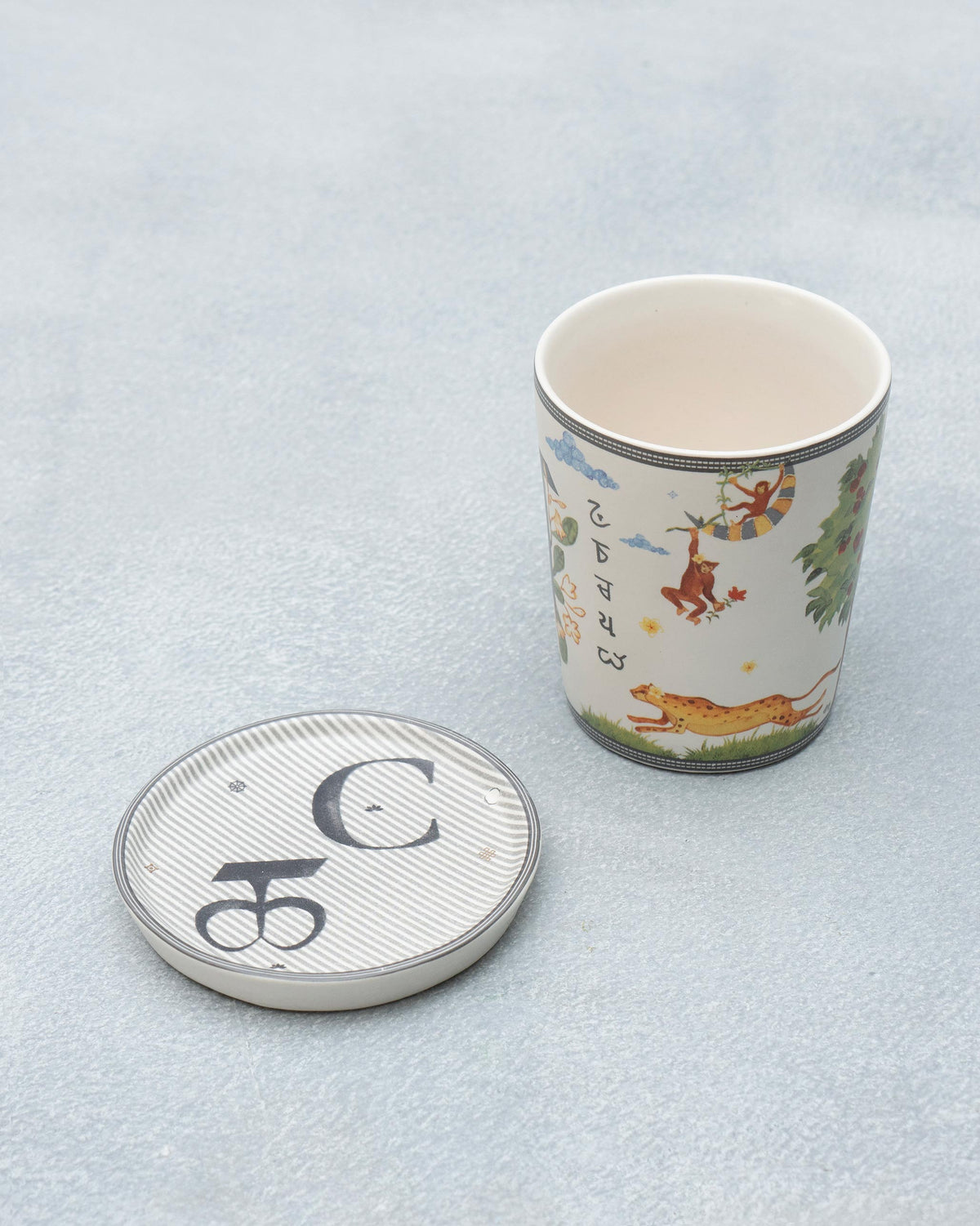 C Alphabet mug with leopard and monkey motifs beside its C coaster.