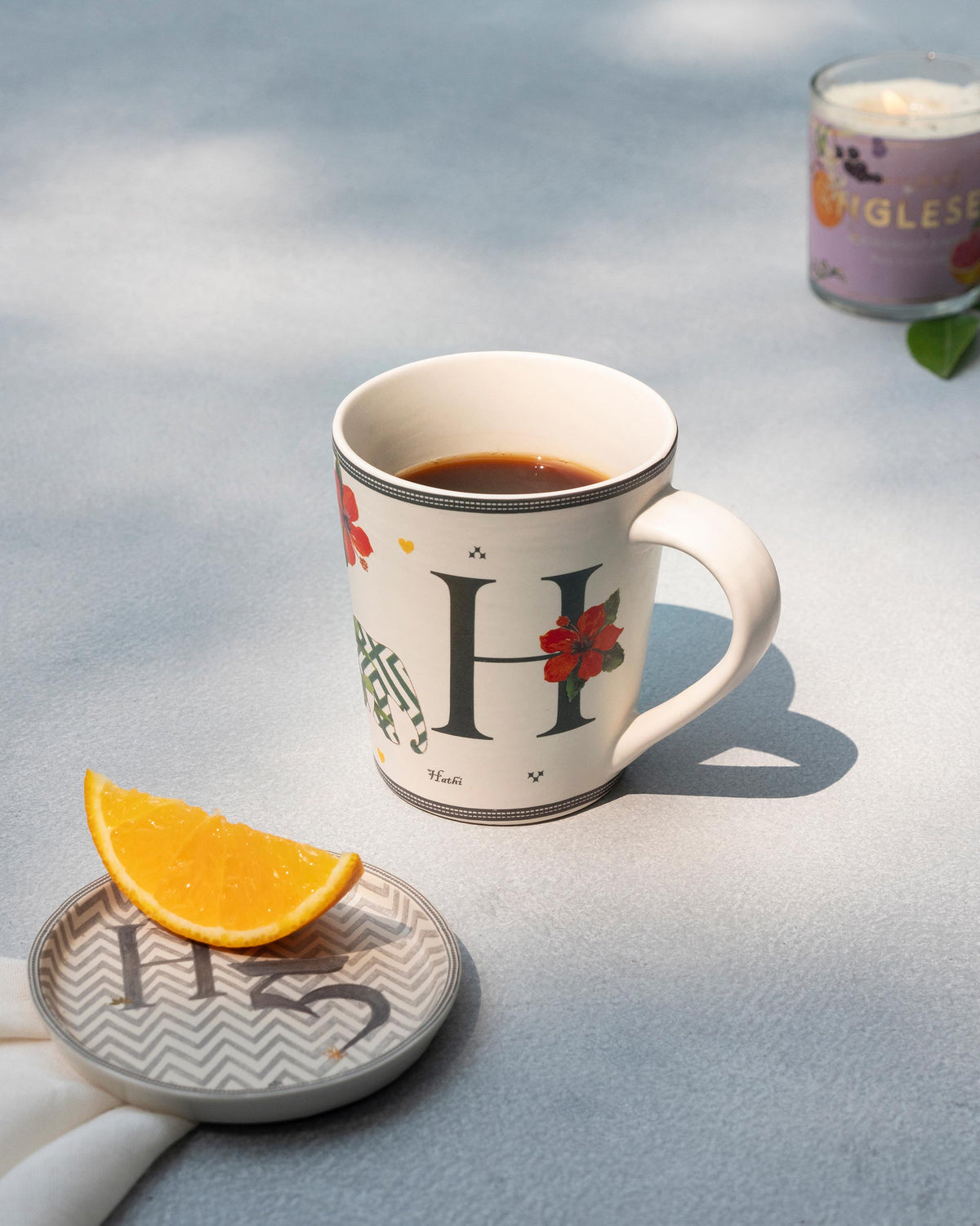 H Alphabet mug filled with coffee beside a matching letter H coaster.