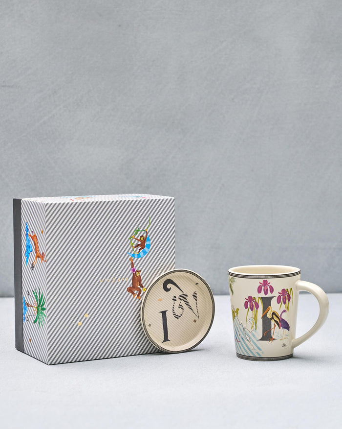 I alphabet mug with crane and iris beside matching coaster and gift box.