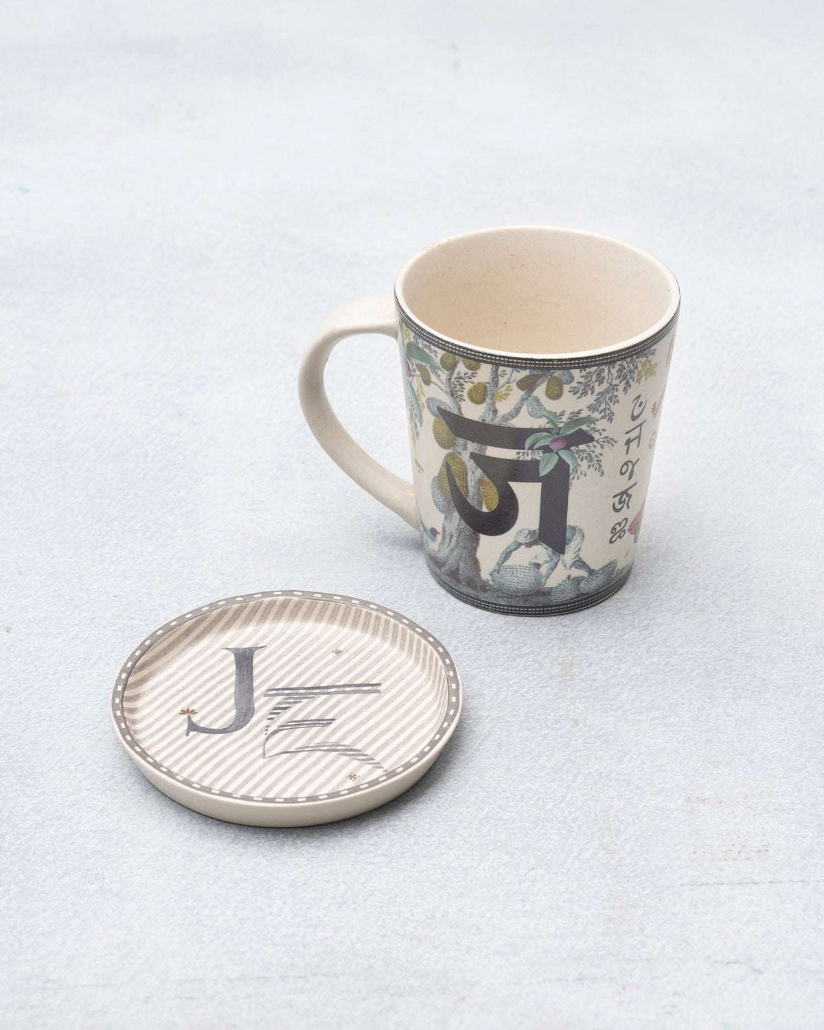 J Alphabet mug with Devanagari ज and fruit tree beside a letter J coaster.