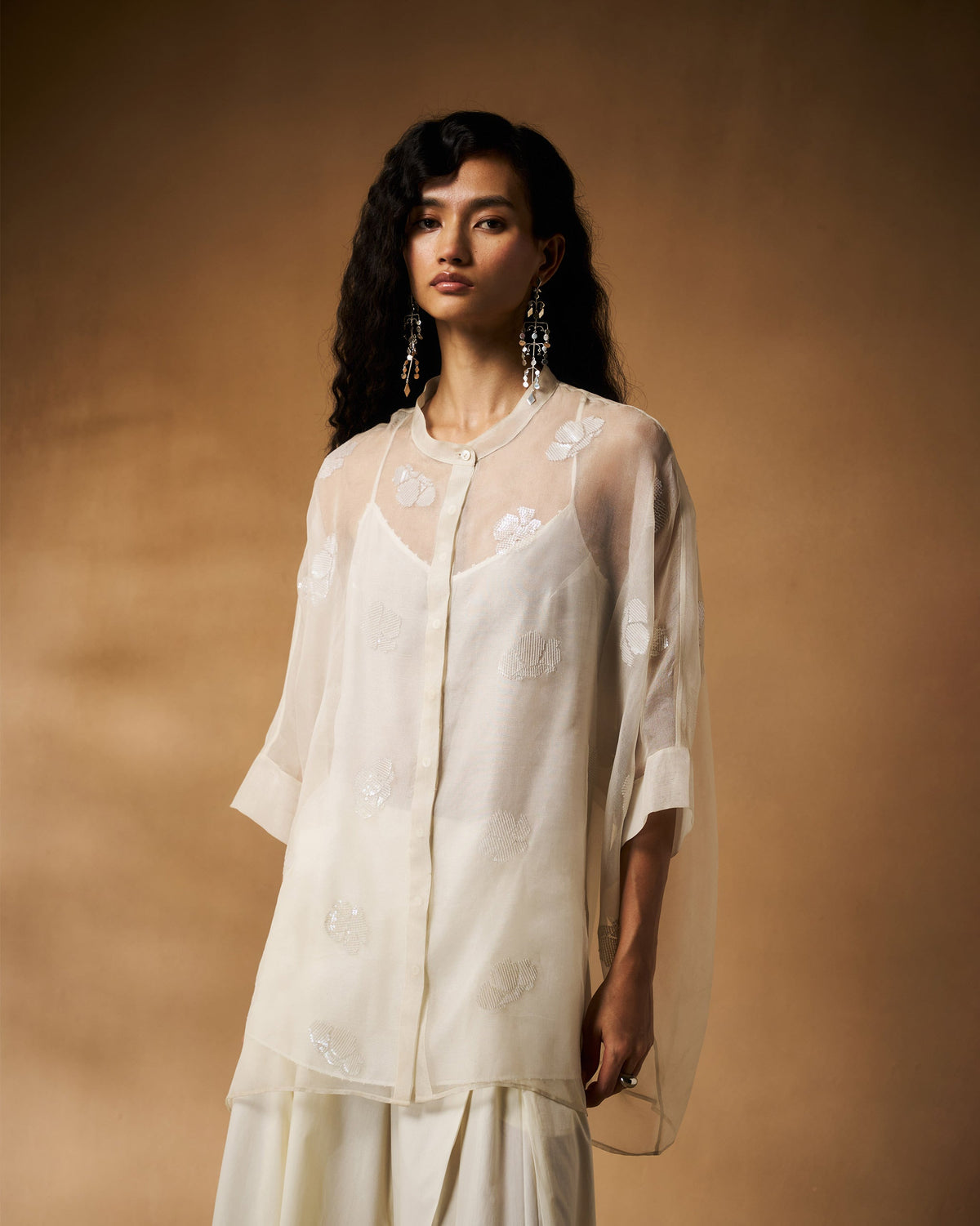 Person wearing an ivory Afra shirt with a band collar and sheer organza sleeves.