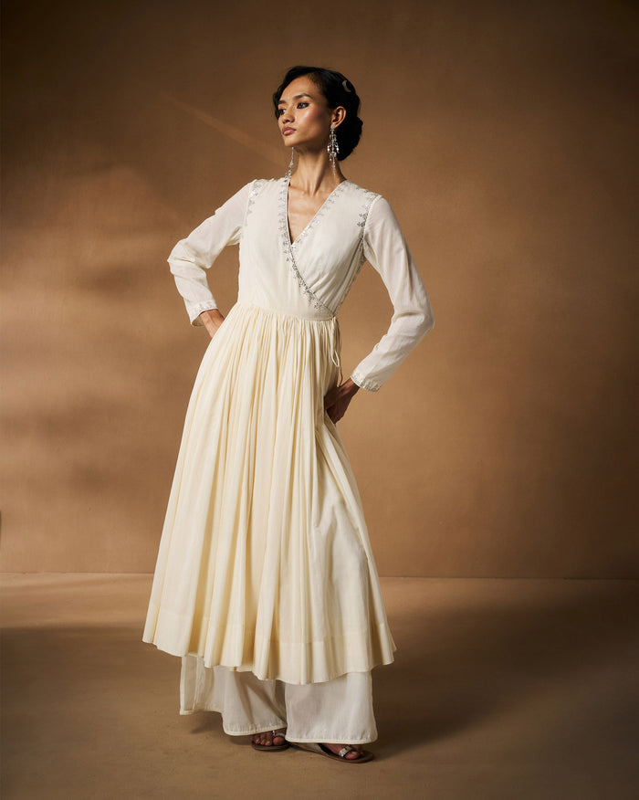 Person wearing an ivory Aafreen Angrakha with silver embroidered neckline.