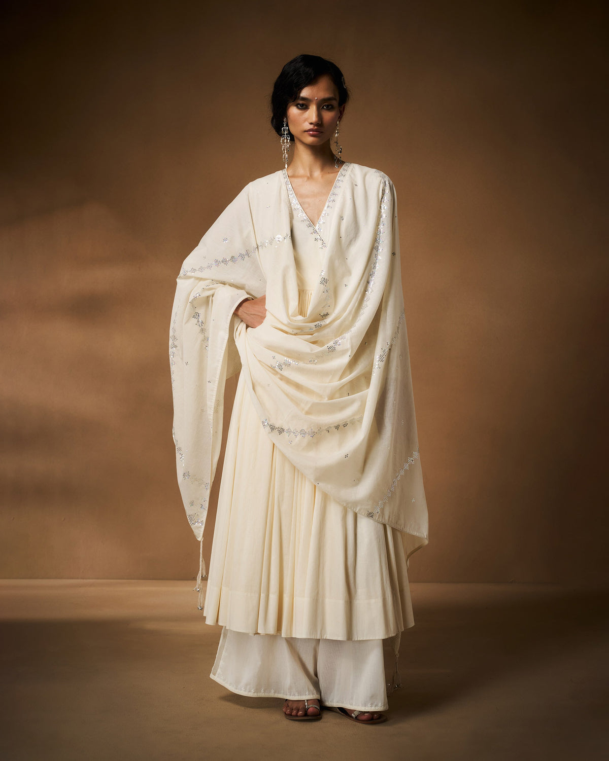 Person wearing an ivory Aafreen Angrakha with a silver embroidered dupatta.