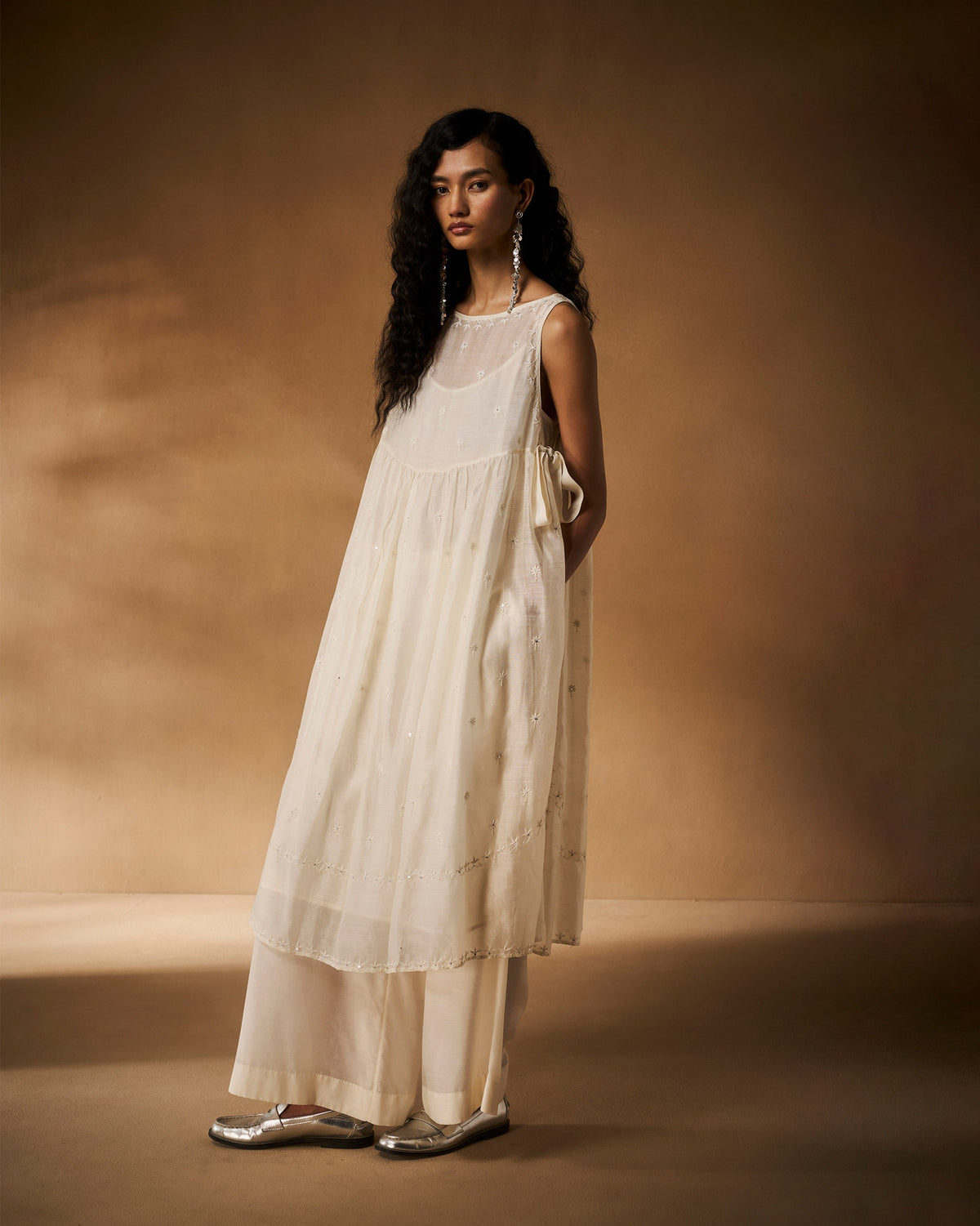 Ivory sheer Afra tunic with empire gather, side bows, and chikankari embroidery.