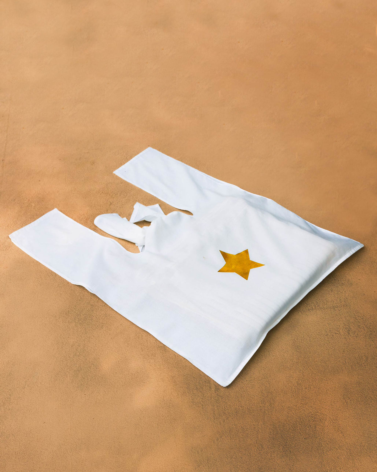 White tote bag with a gold star print.