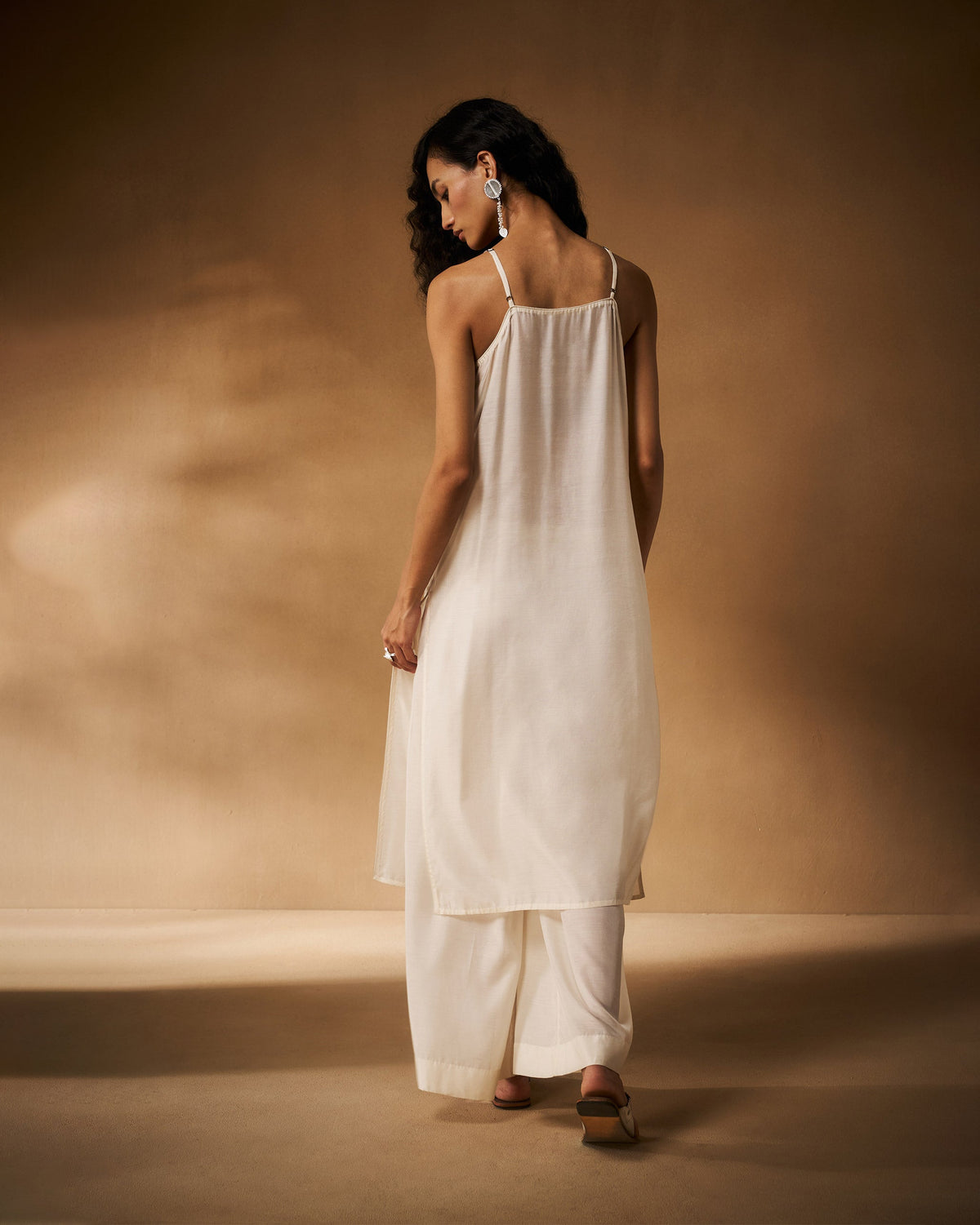 Back of an ivory camisole with thin spaghetti straps.