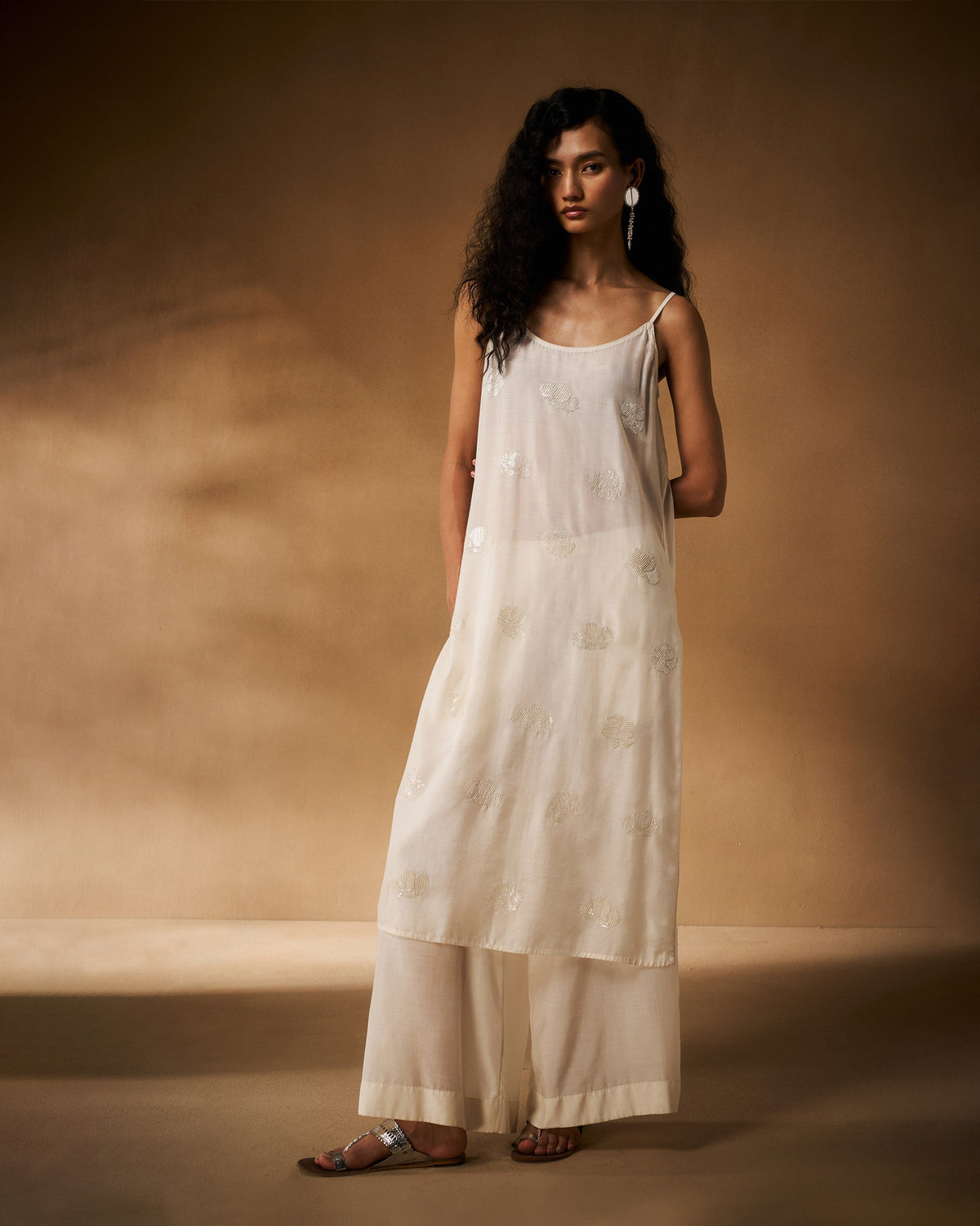 Person wearing a long ivory embroidered camisole.