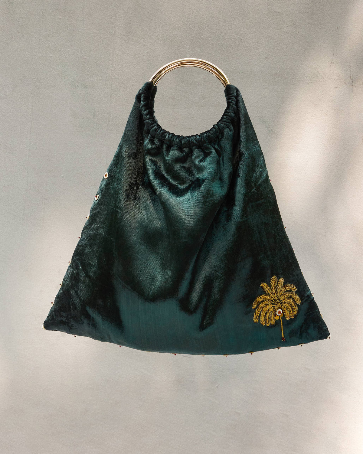 Tangier Tote with a gold ring handle and palm embroidery.