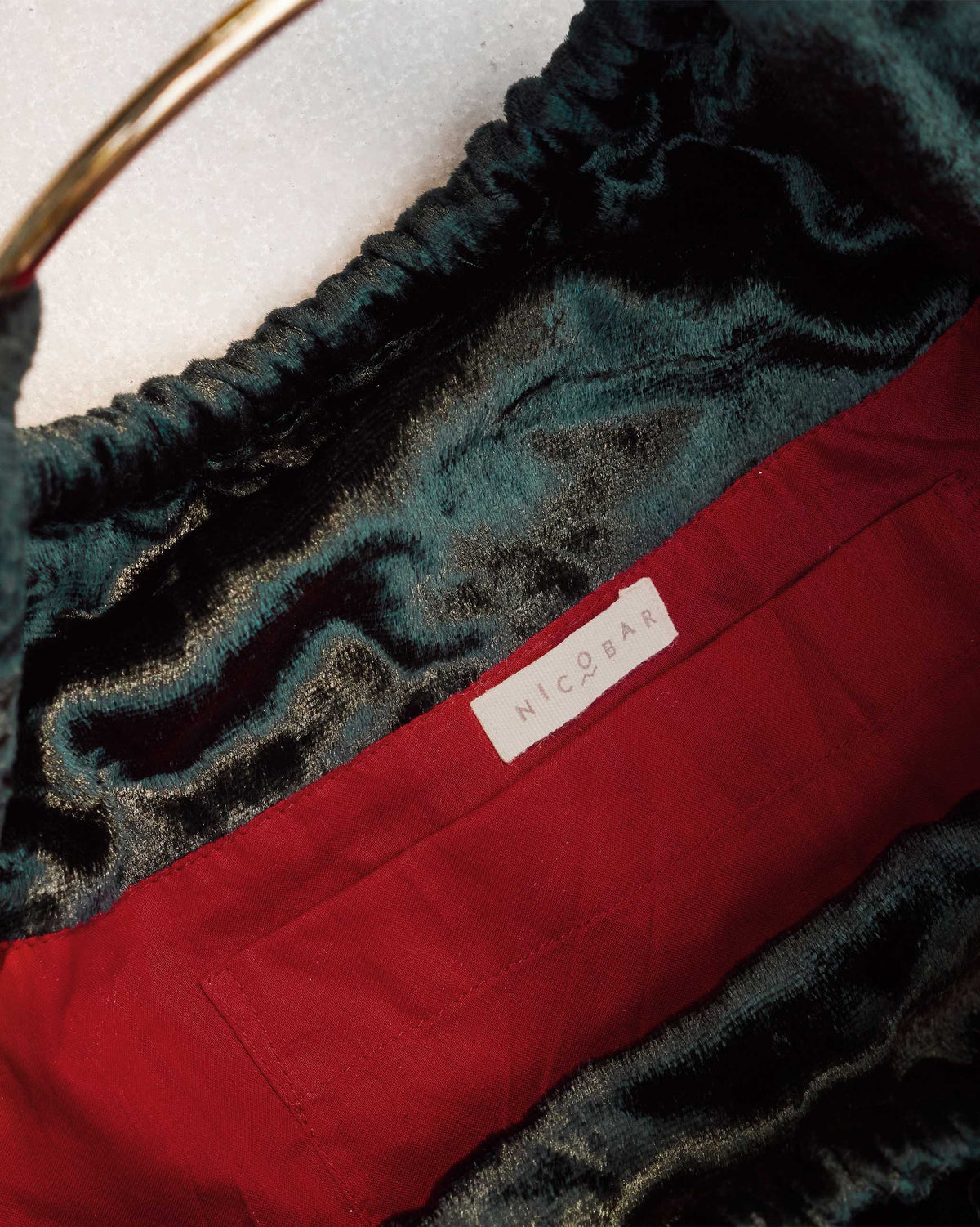 Inside of the Tangier Tote showing a red lining and Nicobar label.