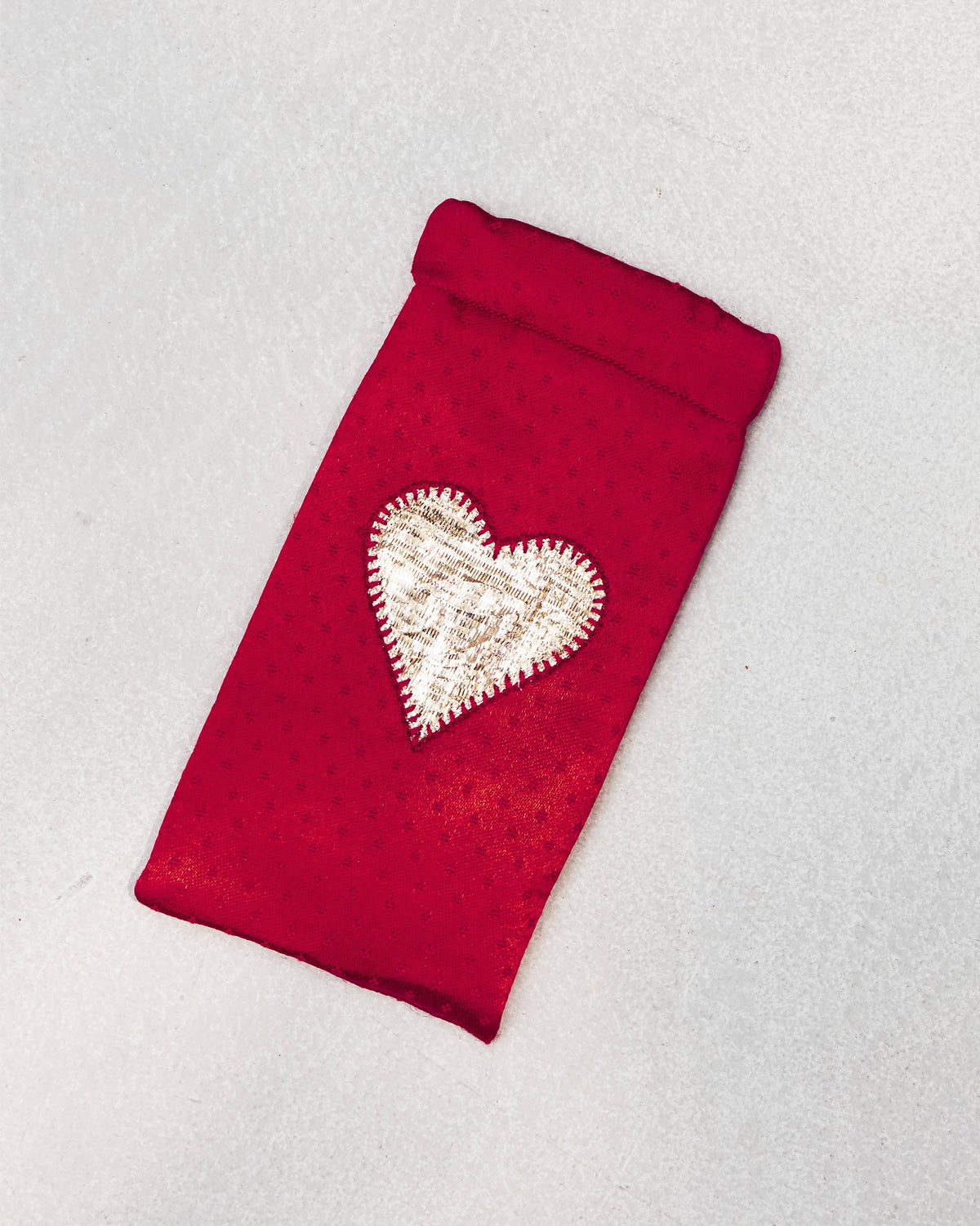 Happy Heart Spec Case tilted on a light surface, showing its heart patch.