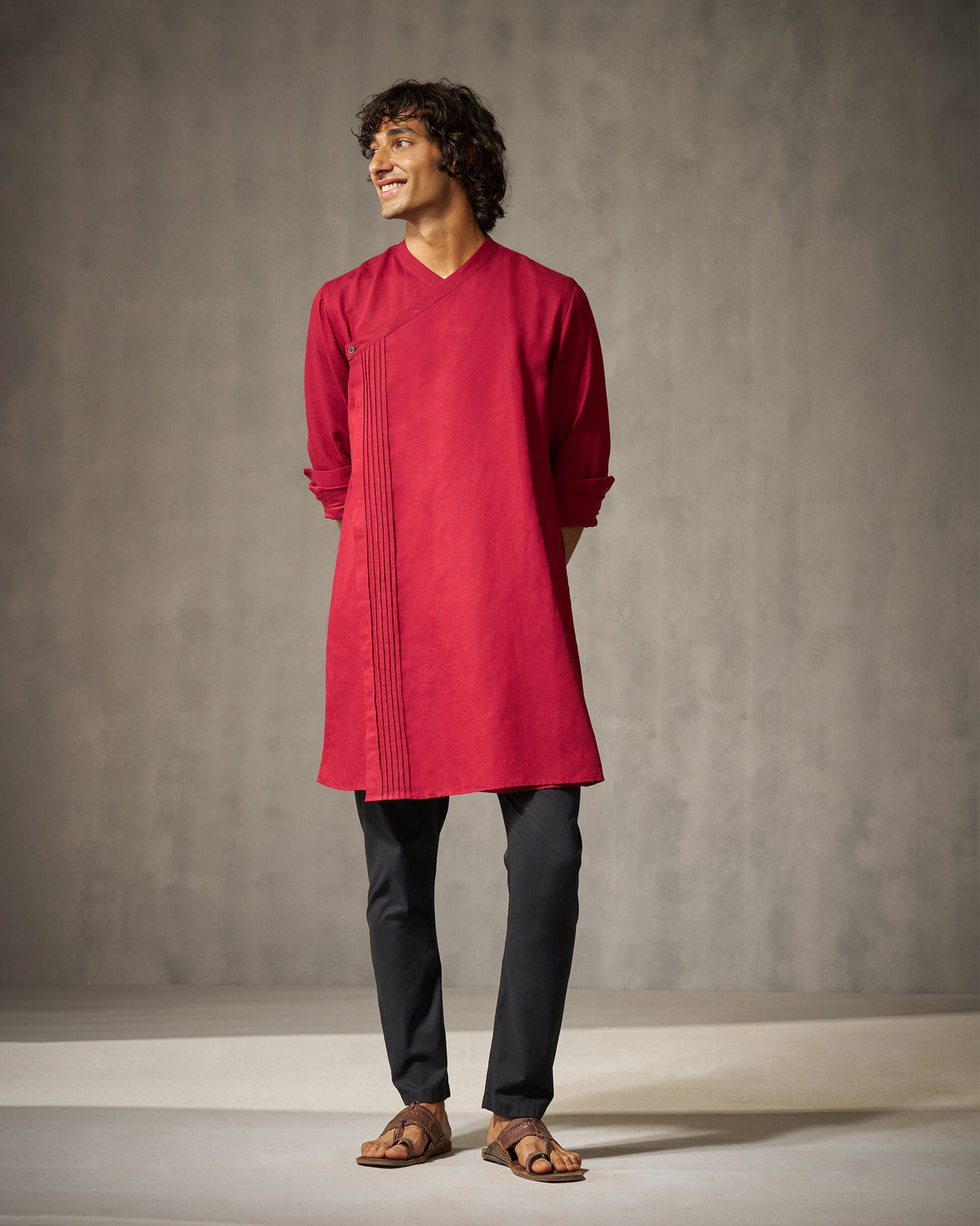 Person wearing a red Staple kurta with a pleated wrap front.