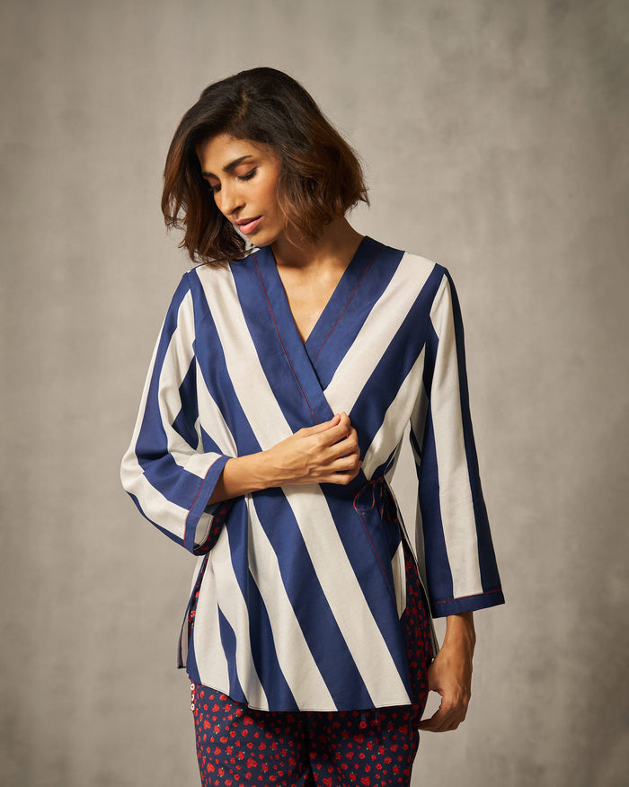 Person wearing a navy and ivory striped Fern wrap top.