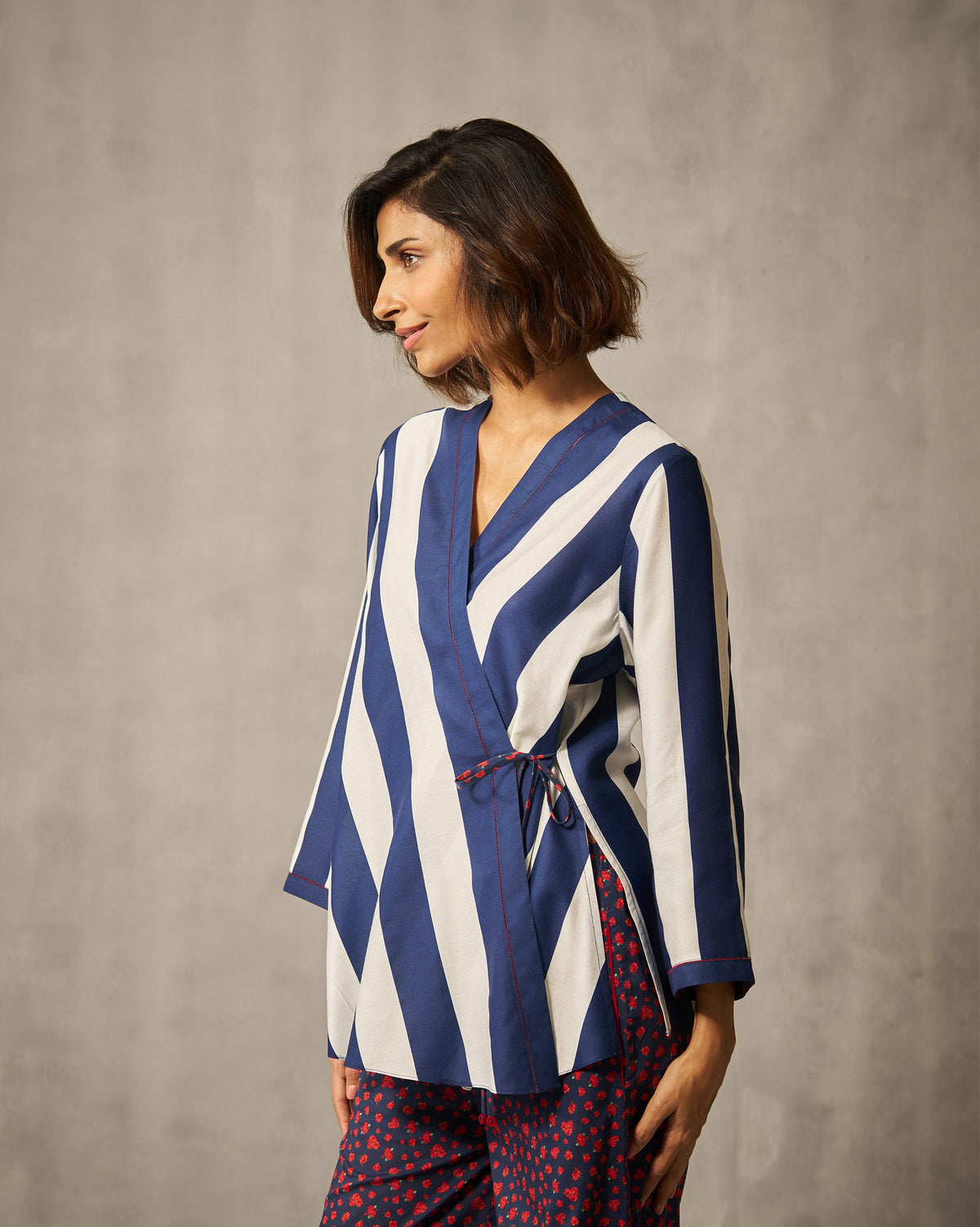 Side view of a navy and ivory striped Fern wrap top worn by a person.
