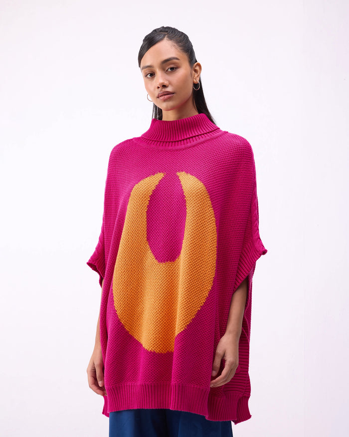 Person wearing the Baggy Sweater in fuchsia with an orange knit motif.