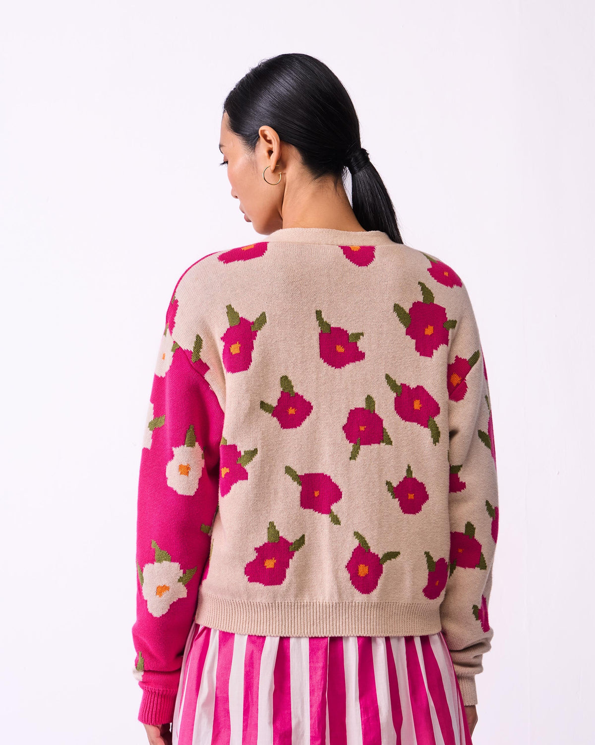 Back of Raven Cardigan with fuchsia flowers on oatmeal, worn by a person.