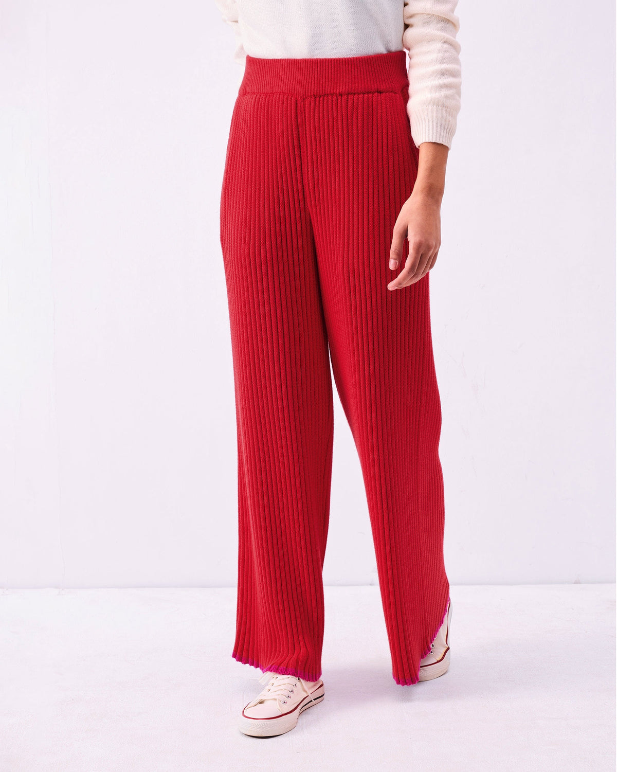 Person wearing Ribbed Knit Trousers in bright red with a high waist.