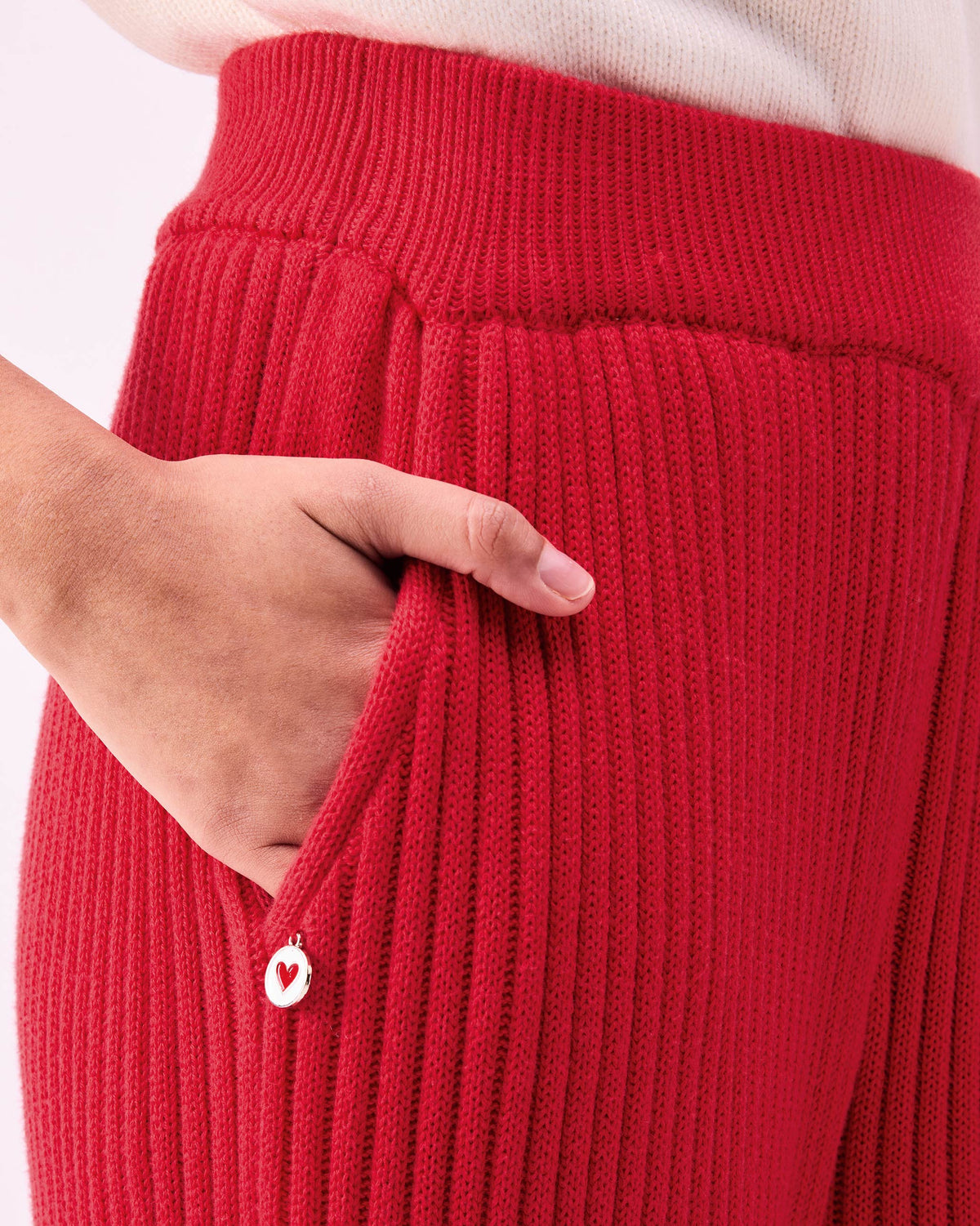 Close-up of Ribbed Knit Trousers pocket with a white heart tag.