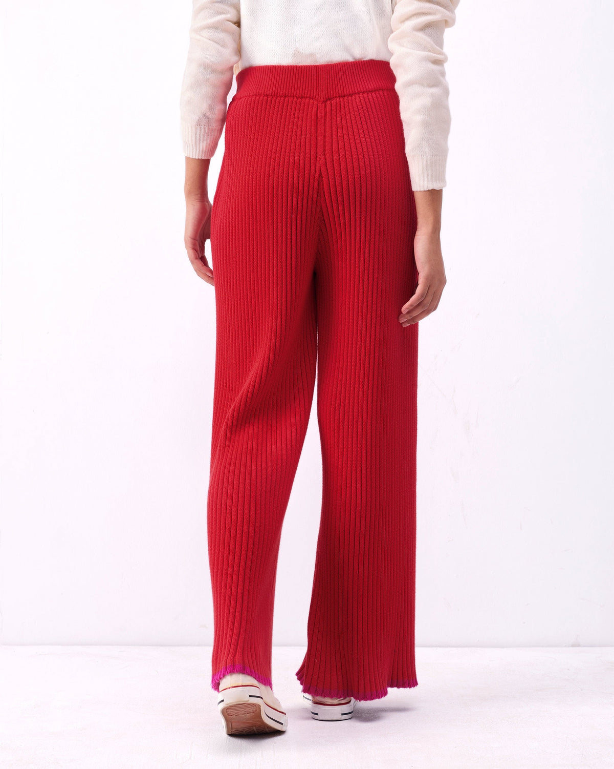 Back of Ribbed Knit Trousers in bright red, worn by a person.