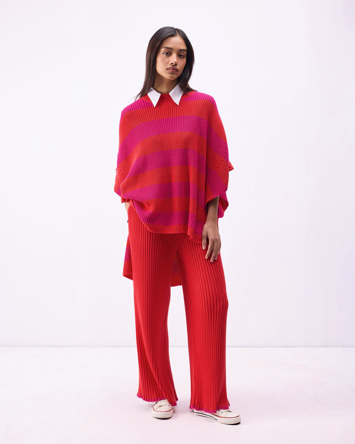Full-length view of Ribbed Knit Trousers in bright red, worn by a person.