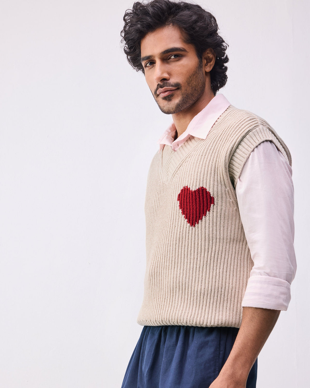 Side view of the Yule V-neck sweater with a red knitted heart.