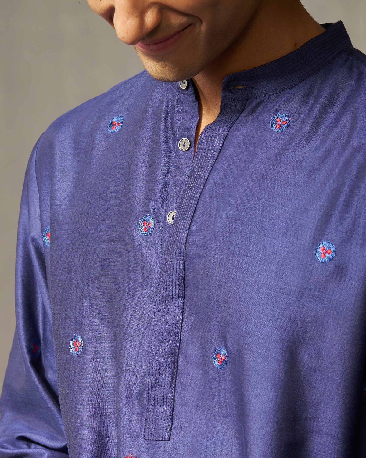 Close-up of a navy Neckband kurta showing the band collar and embroidered blooms.
