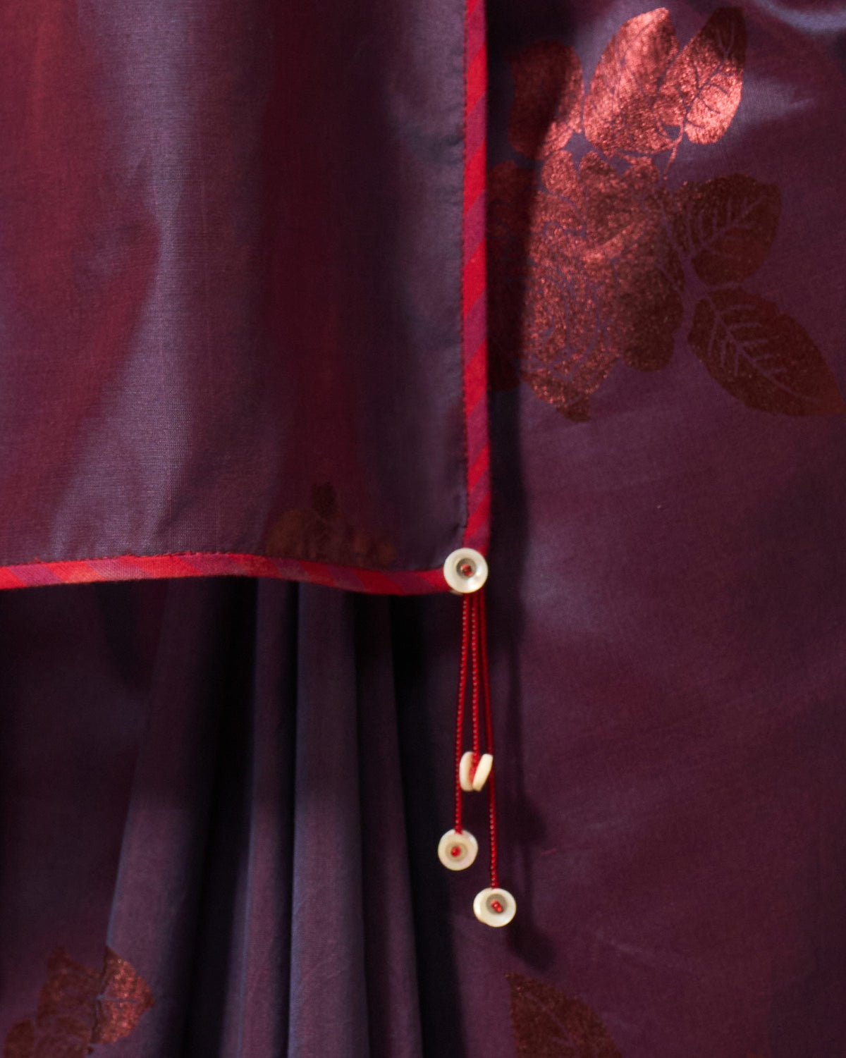 Close-up of Rose Rush Sari edge showing a red border and bead tassel.