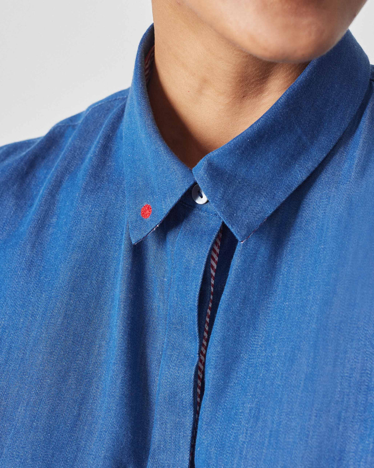 Close-up of the Daisy top collar with a red embroidered dot on the tip.