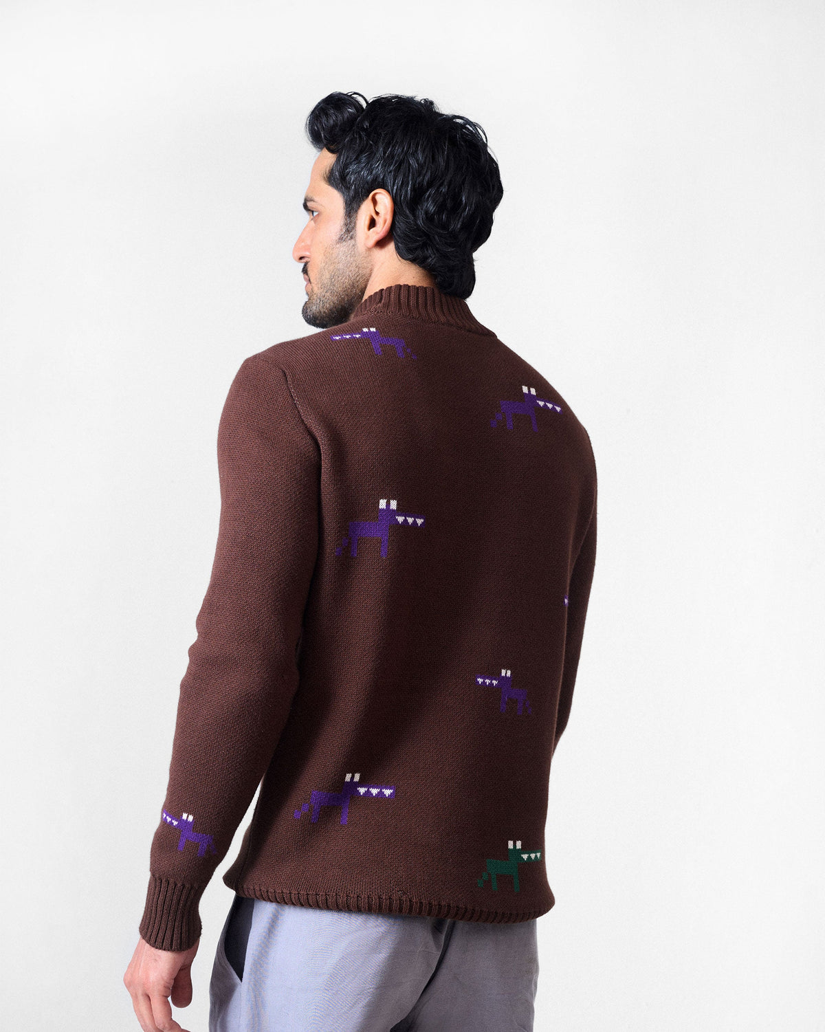 Back of a brown crew neck sweater with scattered pixel animal motifs.