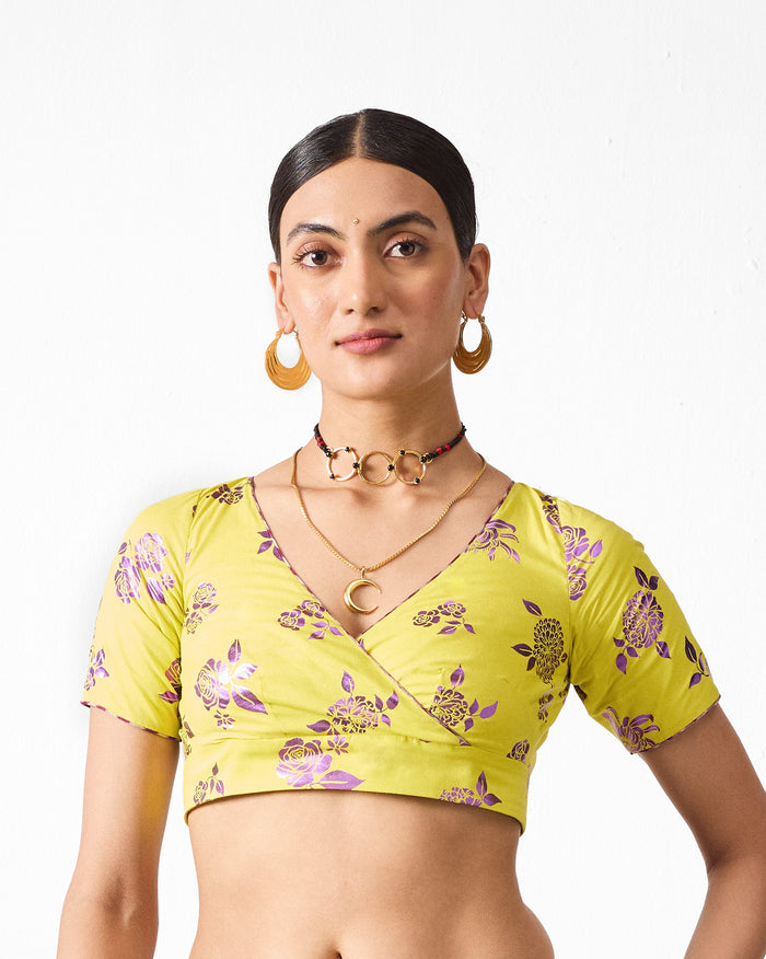 Person wearing a lime Saanjh blouse with a purple floral print.