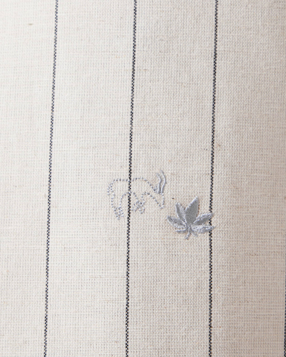 Close-up of elephant and leaf embroidery on an ivory Riverine Shirt.