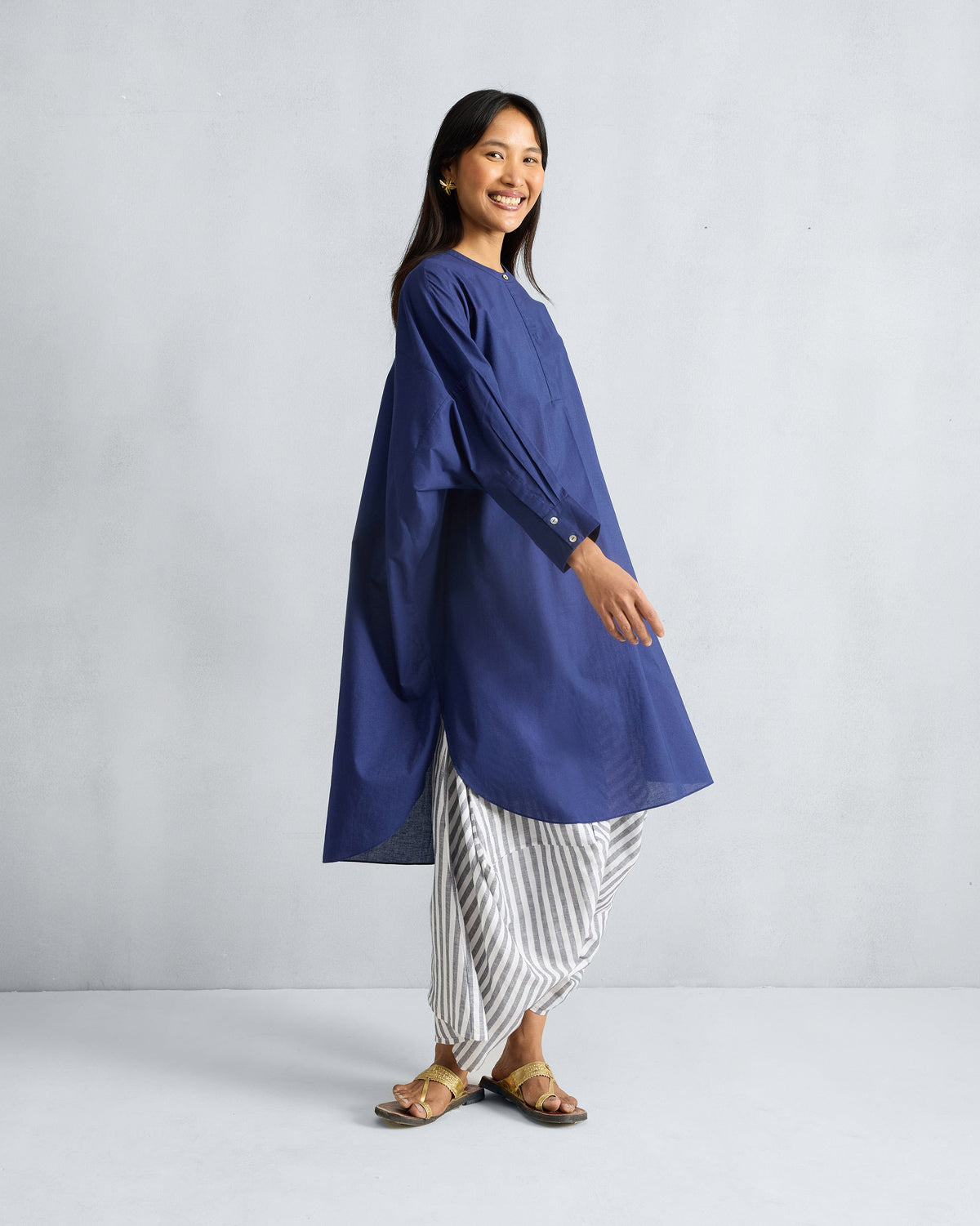Side view of an ink blue Lazy Sunday tunic showing side slits and a curved hem.
