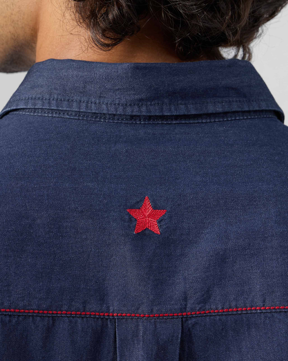 Close-up of a red star on the back of an indigo denim Classic shirt.