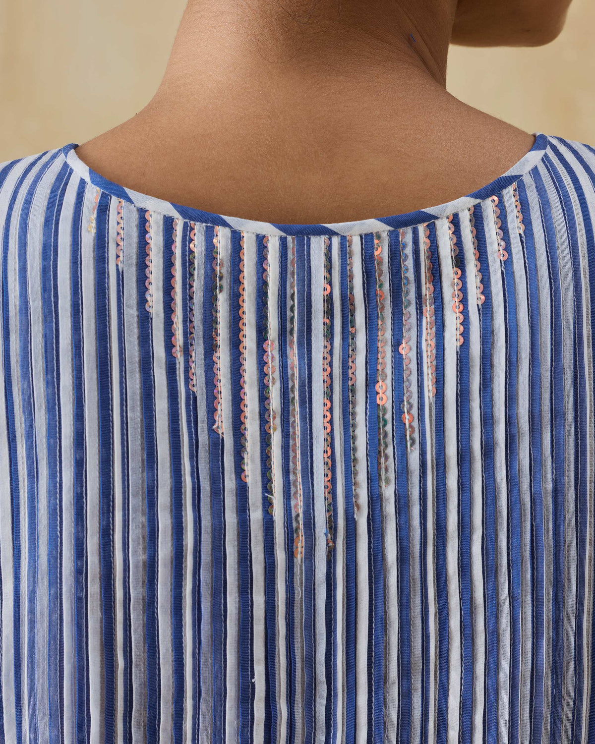Close-up of a cobalt striped top with sequins at the back neck.