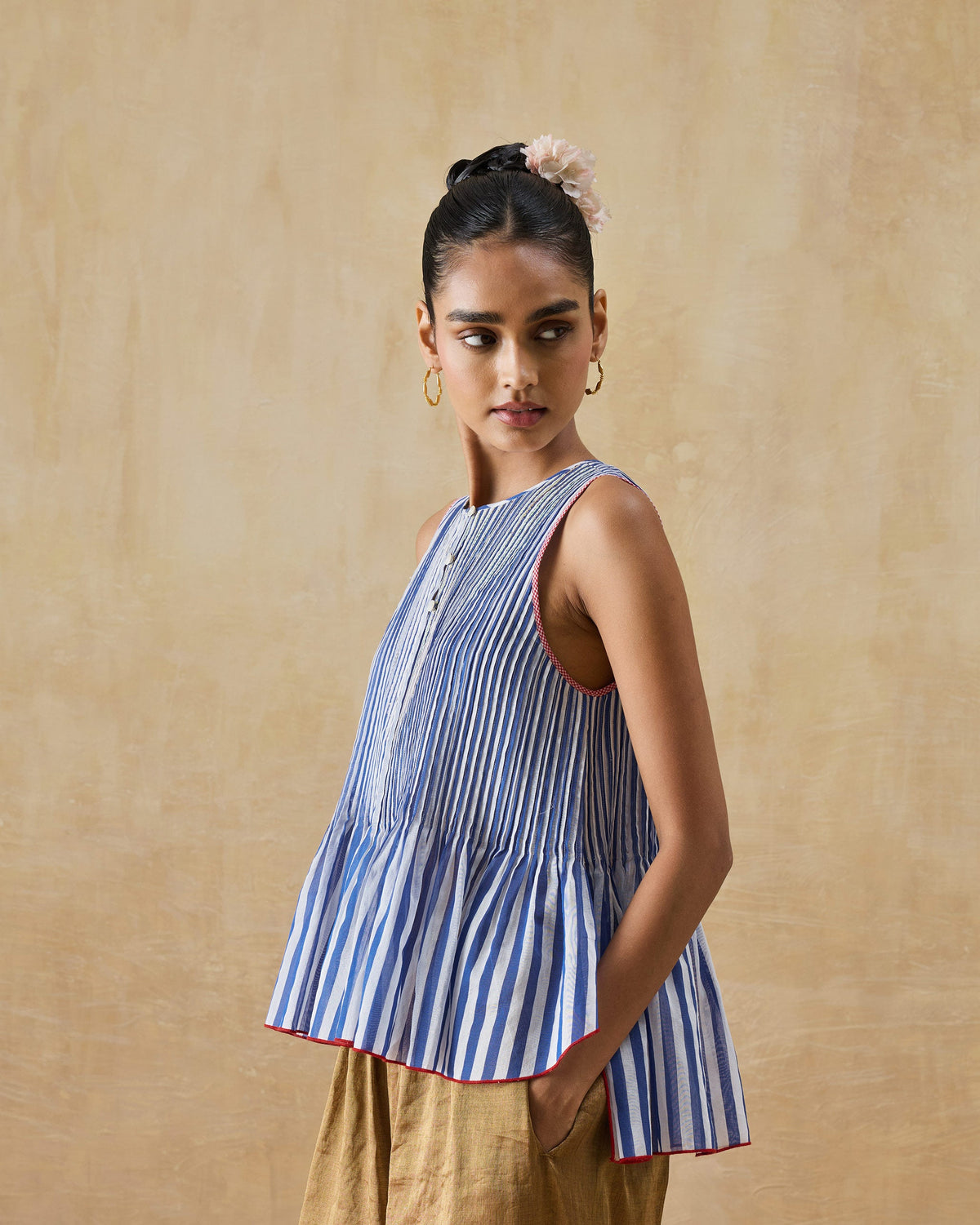 Person wearing a cobalt and ivory striped peplum top with red trim.