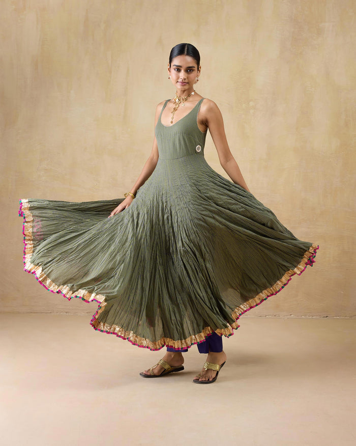 Person wearing a purple-and-lime check Kochi kurta with a flared skirt and gold hem.