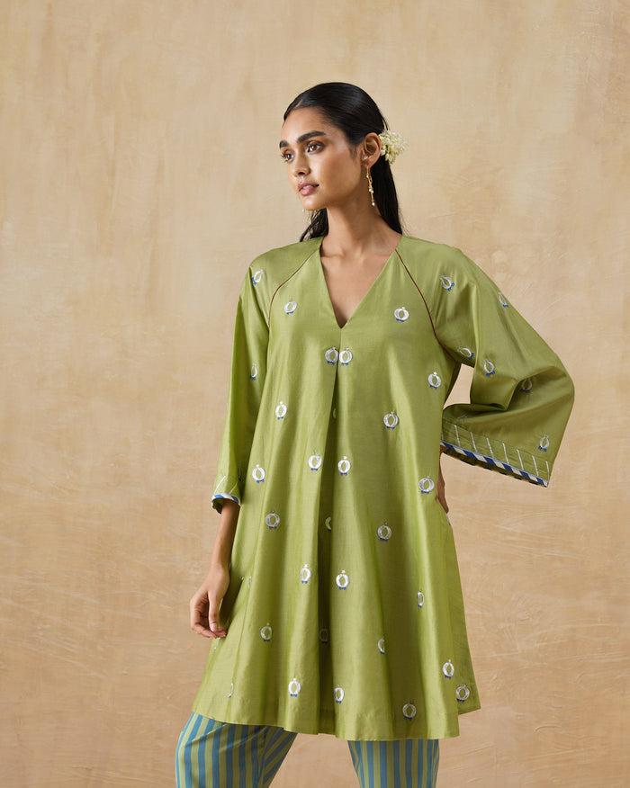 Person wearing an olive green Revelry kurta with white and blue motifs.