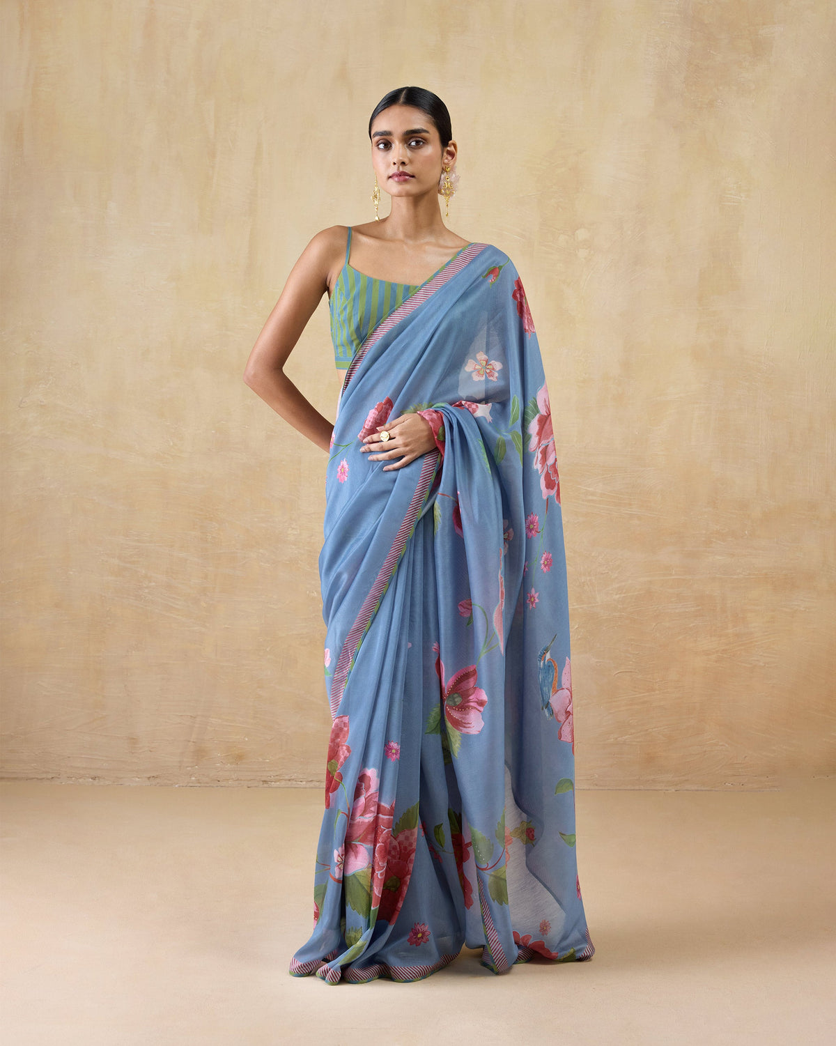 Full-length view of a blue First Bloom sari with a pink rose print worn by a person.